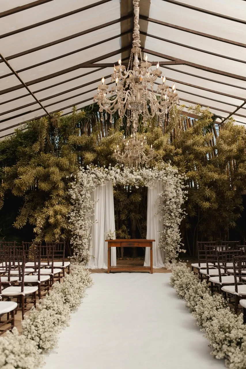O corredor da cerimônia vazio, com o arco de flores ao fundo.