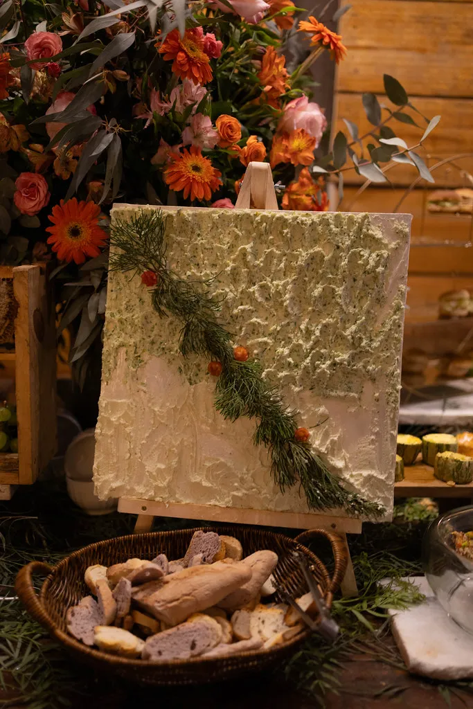 A mesa de doces montada, com frutas e arranjos ao lado do bolo.