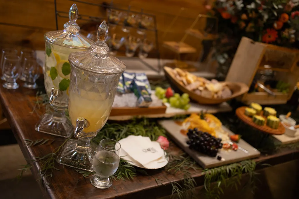 A ilha de buffet servida, com tábuas de frios e limonada em jarras.